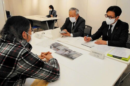 空き家の取り扱いについて助言を受ける相談者（左）