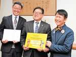 稲嶋社長（右）から年間パスポートを受け取る広田市長（中央）＝３日、倉吉市役所