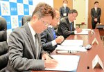 協定書に署名する（手前から）石倉支部長、和田会長、大谷学長