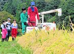 たわわに実ったコシヒカリをコンバインで手際よく刈り取っていくメンバー