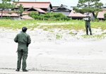 砂浜の奥行きや傾斜などを測定する隊員ら＝１２日、琴浦町逢束の逢束海岸