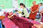 被災して負傷した僧侶を見舞う田中さん（中央）＝マンダレー（「懐」提供）
