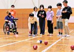 松下選手（左）に挑戦する児童ら＝６日、倉吉市海田西町１丁目の河北小
