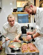  鳥取和牛を細かく切り、和がらしなどであえてパンに乗せるブルスケッタを作るホラークさん（左）とスコペッツさん＝２６日、湯梨浜町田後のやまのおかげ屋 