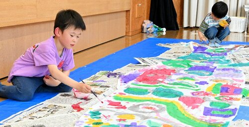 思い思いの色でこいのぼりを彩る子どもたち