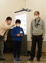 職員に操縦を教わりながらドローンを飛ばす参加者（中央）