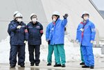 中国電力の担当者（右側）から防波壁など安全対策の状況について説明を受ける原子力規制委員会の関係者＝２６日、松江市鹿島町の島根原発構内