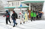 雪の降る中、生山駅を出発する参加者＝１８日、日南町生山