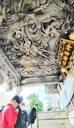 竜の彫刻の下で手を合わせる参拝者ら＝１日、琴浦町赤碕の神崎神社
