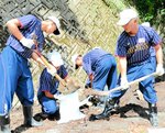 台風の影響で用水路に堆積した土砂をかき出し、土のうを作る生徒ら＝２７日、鳥取市佐治町加瀬木