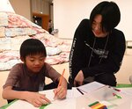  児童と会話しながら、美術作品が楽しめるよう導くファシリテーター役の大学生（右）＝７日、鳥取市の鳥取県立博物館 