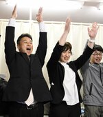 支援者らと万歳をして初当選を祝う前住さん（左）＝９日午後１０時５５分、若桜町若桜の選挙事務所