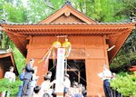 くす玉を割って改修工事の完了を祝う住民や工事業者＝２５日、香美町村岡区大笹の太田神社