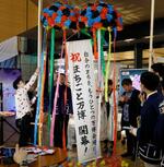 　大阪・関西万博を盛り上げようと、繁華街にオープンした居酒屋「ＥＸＰＯ酒場」でくす玉を割る関係者＝１１日午後、大阪市北区
