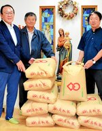 竹内施設長（右）に新米を贈る松本副代表理事（中央）と奥森理事長
