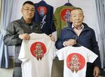 　遮光器土偶が描かれたＴシャツを持つ都南建設の長沢寿八さん（右）と敬一さん＝盛岡市