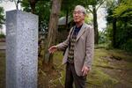　登戸研究所跡に建てられた碑を説明する渡辺賢二。いまは明治大学生田キャンパスとなっている＝川崎市多摩区