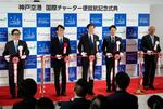 　国際チャーター便の就航記念式典で、テープカットする神戸市の久元喜造市長（中央）ら＝１８日午前、神戸空港