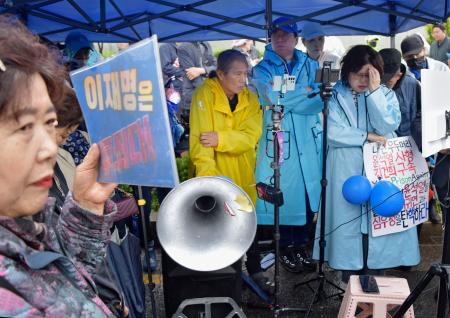 　１日、ソウルの韓国最高裁前で、最大野党「共に民主党」の李在明前代表に対する判決を険しい表情で聞く支持者ら（共同）