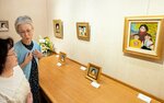 来場者に作品を解説する丸山さん（左から２人目）