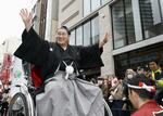 　千葉県柏市で行われた横綱昇進を祝うパレードで、声援に手を振って応える大相撲の新横綱豊昇龍。同市とは故郷のモンゴルから留学して高校３年間を過ごした縁があり、沿道に集まった延べ約２万５千人が祝福した＝１６日午後