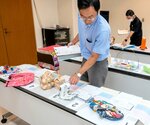 児童たちが出品した力作を見て回る審査員＝１２日、米子市両三柳の新日本海新聞社西部本社