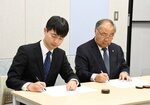 協定書に署名する野口会長（右）と房安会長＝２日、倉吉市上井町１丁目の日本海新聞中部本社多目的スペースさくら