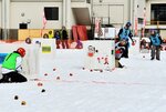 シェルターに身を潜めながら相手に向かって球を投げる選手＝４日、香美町小代区実山の小代中グラウンド