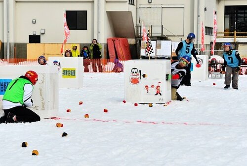 シェルターに身を潜めながら相手に向かって球を投げる選手＝４日、香美町小代区実山の小代中グラウンド