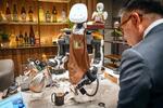 　ＡＬＳ患者の藤田美佳子の遠隔操作でコーヒーを入れる分身ロボット「テレバリスタ」。肩に乗せた小型ロボットで客と会話できる＝２０２４年１２月、東京・日本橋の「分身ロボットカフェ　ＤＡＷＮ　ｖｅｒ．β」（撮影・京極恒太）