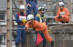 真剣な表情でロープブリッジ渡過に挑む消防隊員＝６日、鳥取市吉成の鳥取消防署