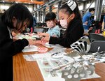 会場でキーホルダー作りを体験する子どもたち＝１３日、鳥取市古海