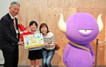 小谷総局長から記念品を受け取り、笑みをこぼす小谷麻琴さん（中央）と弓子さん（右）＝６日、倉吉博物館