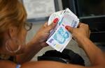 　アルゼンチンのスーパーで通貨ペソを数える人＝１月（ロイター＝共同）