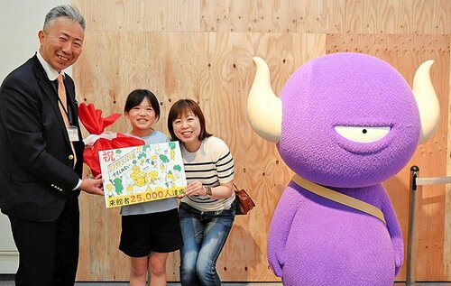 小谷総局長から記念品を受け取り、笑みをこぼす小谷麻琴さん（中央）と弓子さん（右）＝６日、倉吉博物館