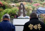 　「畜魂碑」の前で黙とうする参列者＝２０日午前、宮崎県都農町