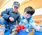 講師の指導を受け、シイタケの植菌に挑戦する児童
