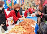 新鮮なカニを買い求める来場者＝１８日、新温泉町の浜坂漁港