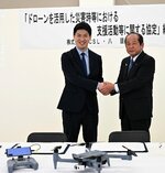 握手を交わす吉田町長（右）と鷲谷社長＝２日、八頭町役場
