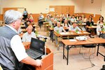 美方署の大須賀警部補（左）から特殊詐欺の手口や被害を防ぐ対策を学ぶ参加者ら＝２３日、香美町香住区上計の上計ふれあい会館