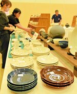 開幕に向けて商品の陳列作業に追われる出展者ら＝１０日、倉吉市上井町１丁目の日本海新聞中部本社ホール