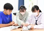 学生（中央）のサポートを受けながら、漫画のせりふから英語のフレーズを探す参加者ら＝２日、倉吉市下田中町の倉吉東高