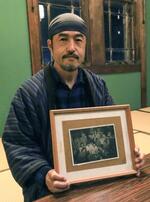 　「水俣病を告発する会」のメンバーらが写った写真を手にする小坂勝弥さん＝１１月、京都市