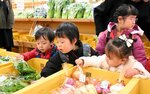 商品の中からお目当ての野菜を見つけて買い物をする園児ら