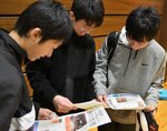 【号外に笑顔】 教室後に渡された記念号外を興味深そうに見る参加者
