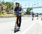 電動キックボードに試乗する大学生＝１日、鳥取市福部町湯山