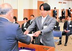 緊張した表情で太田垣組合長（左）から辞令を受け取る新入職員＝３１日、豊岡市九日市のＪＡたじま本店