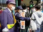 　事故現場近くで交通安全啓発のチラシなどを配る警察官＝１２日午後、京都市東山区