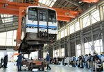 大型クレーンで車体をつり上げる実演を見学する来場者たち＝２８日、鳥取県米子市日ノ出町２丁目の後藤総合車両所