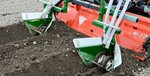 車輪で溝の底に盛り土を作る。白ネギの苗の根付きに効果があるという